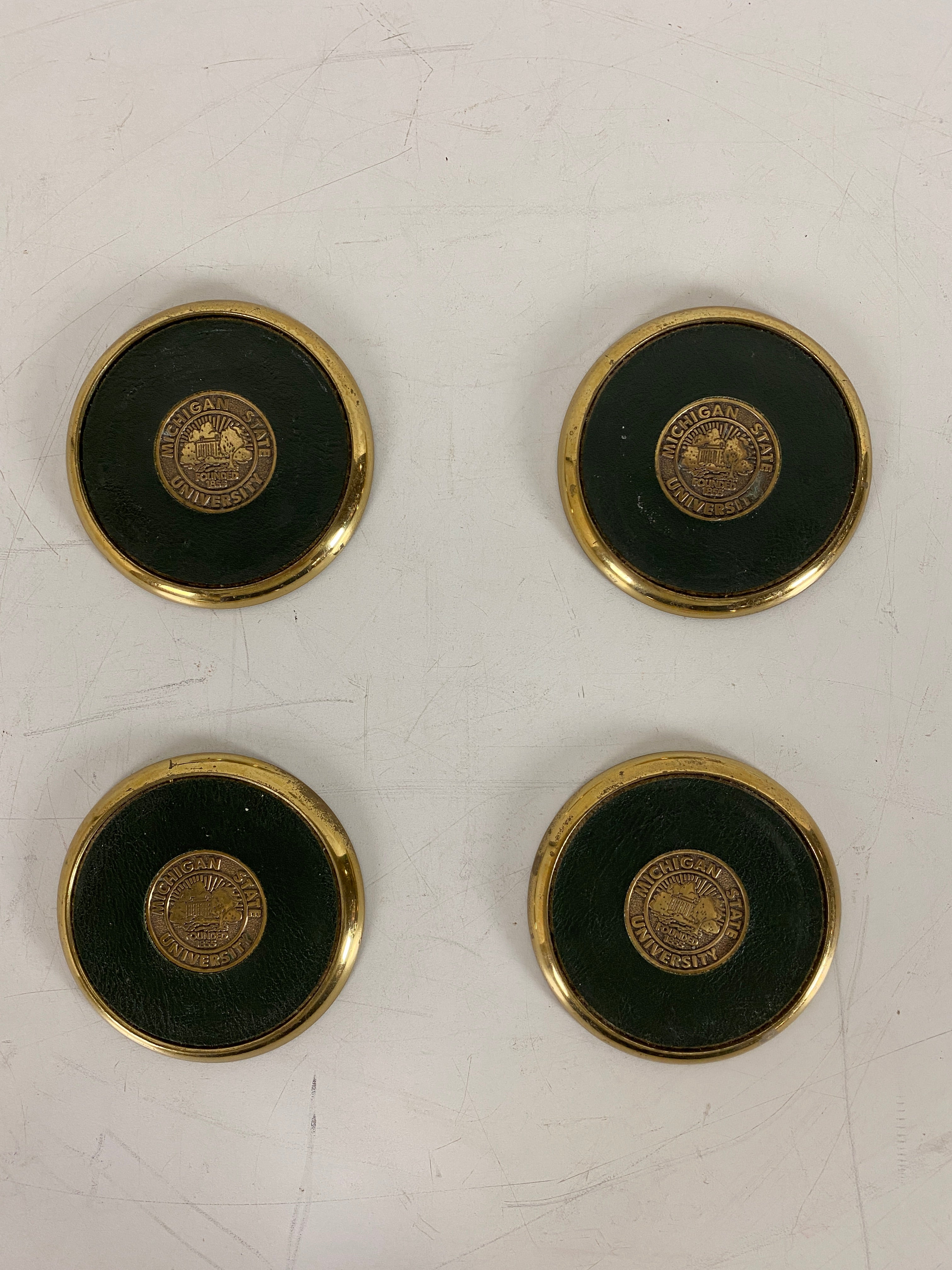 Set of 4 Brass MSU Coasters