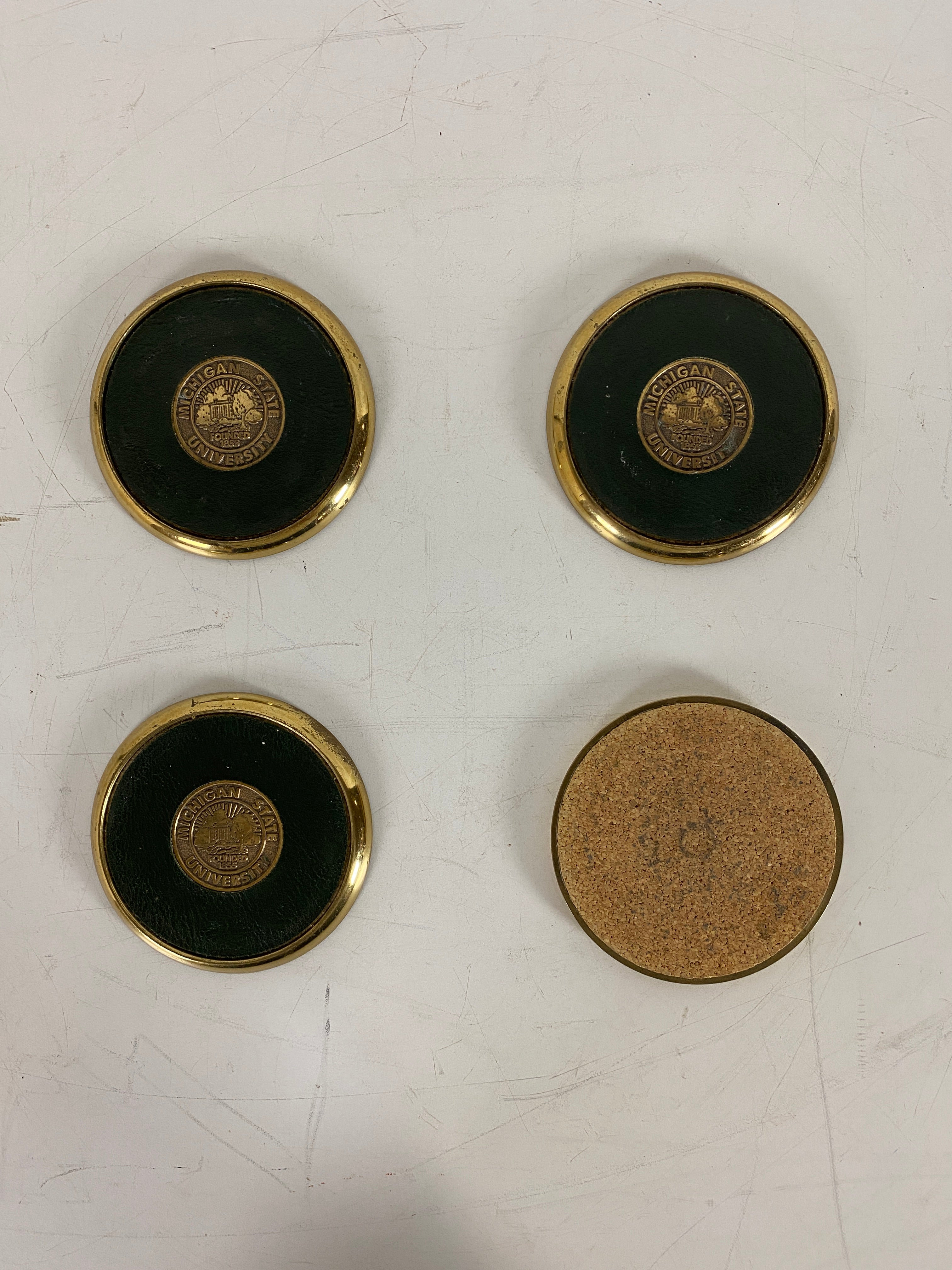 Set of 4 Brass MSU Coasters